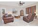 Cozy living room with leather seating, a wooden chest, and a ceiling fan, offering comfortable living space at 30066 N Holly Dr, San Tan Valley, AZ 85144
