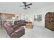 Open concept living room features a leather sofa set, ceiling fan, and views of the kitchen and desert landscape at 30066 N Holly Dr, San Tan Valley, AZ 85144
