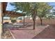 Landscaped backyard with covered patio, mature trees, and easy-care gravel for a serene outdoor experience at 325 W Seaside Dr, Casa Grande, AZ 85122