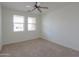 Light-filled bedroom with carpet flooring, a ceiling fan, and two large windows at 325 W Seaside Dr, Casa Grande, AZ 85122