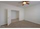 Bright bedroom with neutral carpet, white walls, and a ceiling fan at 325 W Seaside Dr, Casa Grande, AZ 85122