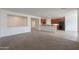Open-concept living room featuring neutral carpet and seamless transition to the adjacent kitchen area at 325 W Seaside Dr, Casa Grande, AZ 85122