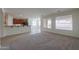Bright living room with neutral carpeting and tiled floors leading to an open-concept kitchen at 325 W Seaside Dr, Casa Grande, AZ 85122
