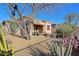 Beautiful backyard showcasing desert landscaping, a covered patio, and mature trees at 32960 N 70Th St, Scottsdale, AZ 85266