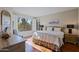 Bedroom with a queen bed, hardwood floors, and large shuttered windows overlooking the landscape at 32960 N 70Th St, Scottsdale, AZ 85266