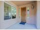 Covered front porch with view to the interior through a large picture window and a decorative door at 32960 N 70Th St, Scottsdale, AZ 85266