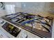 Close-up of stainless steel gas stove top with granite counter top in modern kitchen at 32960 N 70Th St, Scottsdale, AZ 85266