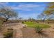 Lush backyard featuring a putting green, desert landscaping, stone bench, and brick patio at 33250 N 71St St, Scottsdale, AZ 85266