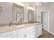 Bright bathroom featuring double sinks, quartz countertop, framed mirrors, and wood flooring at 33250 N 71St St, Scottsdale, AZ 85266