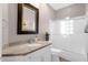 Bright bathroom featuring marble countertop, framed mirror, and glass-enclosed shower at 33250 N 71St St, Scottsdale, AZ 85266