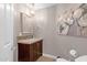 Charming powder room featuring stylish vanity, granite countertop, mosaic backsplash, and elegant light fixture at 33250 N 71St St, Scottsdale, AZ 85266