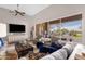 Bright living room features a ceiling fan, large windows, stylish furniture, and backyard views at 33250 N 71St St, Scottsdale, AZ 85266