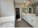 Bathroom with a double vanity, large mirror, walk-in closet and ceramic tile floors at 3463 S 175Th Dr, Goodyear, AZ 85338