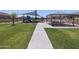 Sidewalk view of a community park featuring a playground, picnic pavilion, and landscaped green spaces at 3819 S 87Th Dr, Tolleson, AZ 85353