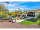 Backyard with a pool, outdoor dining area, manicured landscaping, and mature palm trees at 4114 E Desert Cove Ave, Phoenix, AZ 85028