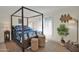 Comfortable bedroom with dark wood canopy bed, shutters, and bright plants at 4114 E Desert Cove Ave, Phoenix, AZ 85028