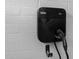 A black Blink HQ electric vehicle charging station is mounted on a white brick wall at 4114 E Desert Cove Ave, Phoenix, AZ 85028