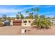 A tan house with a Spanish tile roof features desert landscaping, a two-car garage, and gate at 4114 E Desert Cove Ave, Phoenix, AZ 85028