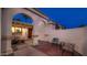 Inviting front entrance features a cozy seating area and stucco arches at twilight at 4114 E Desert Cove Ave, Phoenix, AZ 85028