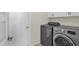 This laundry room features a gray front-loading washer and dryer set with white cabinets above at 4114 E Desert Cove Ave, Phoenix, AZ 85028