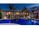A beautiful pool with blue lighting is surrounded by manicured landscaping and tiled walkways at 4114 E Desert Cove Ave, Phoenix, AZ 85028