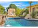 Pool with a water feature, lounge area, travertine tile, and lush landscaping at 4114 E Desert Cove Ave, Phoenix, AZ 85028