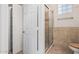 Bathroom with tiled shower, glass door, and glass block window for natural light at 5303 N 7Th St # 242, Phoenix, AZ 85014