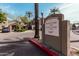 Landscaped entrance with welcoming community sign surrounded by lush trees, creating a serene atmosphere at 5303 N 7Th St # 242, Phoenix, AZ 85014