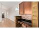 Bright living room with light wood floors and a bar area featuring granite counters and mosaic tile at 5303 N 7Th St # 242, Phoenix, AZ 85014