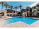 View of community pool, with lounge chairs, shade, desert plants and building at 5303 N 7Th St # 242, Phoenix, AZ 85014
