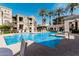 Resort style swimming pool with lounge chairs and umbrellas, surrounded by palm trees and condo buildings at 5303 N 7Th St # 242, Phoenix, AZ 85014