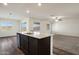 Open concept kitchen with an island, granite countertops and a view of the carpeted living room at 611 W Crowned Dove Trl, Casa Grande, AZ 85122