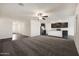 Large living room with dark vinyl floors and neutral carpet, leading to a modern kitchen at 611 W Crowned Dove Trl, Casa Grande, AZ 85122