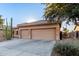 Home's exterior featuring two-car garage, desert landscaping, stone accents, and a well-maintained driveway at 702 S 119Th Ave, Avondale, AZ 85323