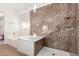 Luxurious main bathroom with separate tub and walk-in shower with elegant tile at 702 S 119Th Ave, Avondale, AZ 85323