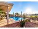 Stunning pool area with desert landscaping, covered patio, and beautiful fence line views at 702 S 119Th Ave, Avondale, AZ 85323