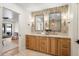 Luxurious bathroom features a double vanity with stylish mirrors, wood cabinets, and elegant fixtures at 7553 E Woodshire Cv, Scottsdale, AZ 85258