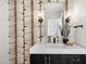 Stylish bathroom vanity features elegant fixtures, textured wallpaper, and contemporary design at 7553 E Woodshire Cv, Scottsdale, AZ 85258
