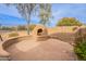 Backyard fireplace, featuring built-in bench and desert landscaping at 7654 W Congressional Way, Florence, AZ 85132