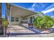 Charming home with covered parking, a front deck, and a lovely orange tree on a sunny day at 7750 E Broadway Rd # 475, Mesa, AZ 85208