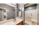 Bathroom with double vanity and tiled floors features walk-in shower with grab bars at 8385 W Vogel Ave, Peoria, AZ 85345