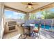 Relaxing covered patio features a built-in BBQ, ceiling fan, and view of the refreshing pool and well-manicured backyard at 8385 W Vogel Ave, Peoria, AZ 85345