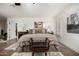Spacious bedroom with neutral colors, tile floors, white shutters, and a decorative seating bench at 8737 E San Vicente Dr, Scottsdale, AZ 85258