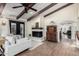 Cozy living room with vaulted ceilings, a white fireplace, exposed beams, and abundant natural light at 8737 E San Vicente Dr, Scottsdale, AZ 85258