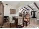 Home office area with wooden beamed ceilings, a writing desk, decorative chairs and a large area rug at 8737 E San Vicente Dr, Scottsdale, AZ 85258
