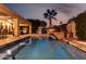 Backyard pool featuring stone surround, waterfall feature, grill and evening sky at 8737 E San Vicente Dr, Scottsdale, AZ 85258