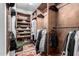 Organized walk-in closet with wooden shelves and hanging racks designed for versatile storage solutions at 8737 E San Vicente Dr, Scottsdale, AZ 85258