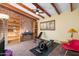 Bright exercise area with brick accent wall, exposed wood beams, and home workout equipment at 945 W 10Th St, Mesa, AZ 85201
