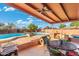 Covered patio featuring an outdoor kitchen, seating area, and view of the pool and backyard at 945 W 10Th St, Mesa, AZ 85201
