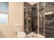 Modern bathroom with a rainfall shower, black tile, and a toilet at 10018 N 103Rd Ave, Sun City, AZ 85351